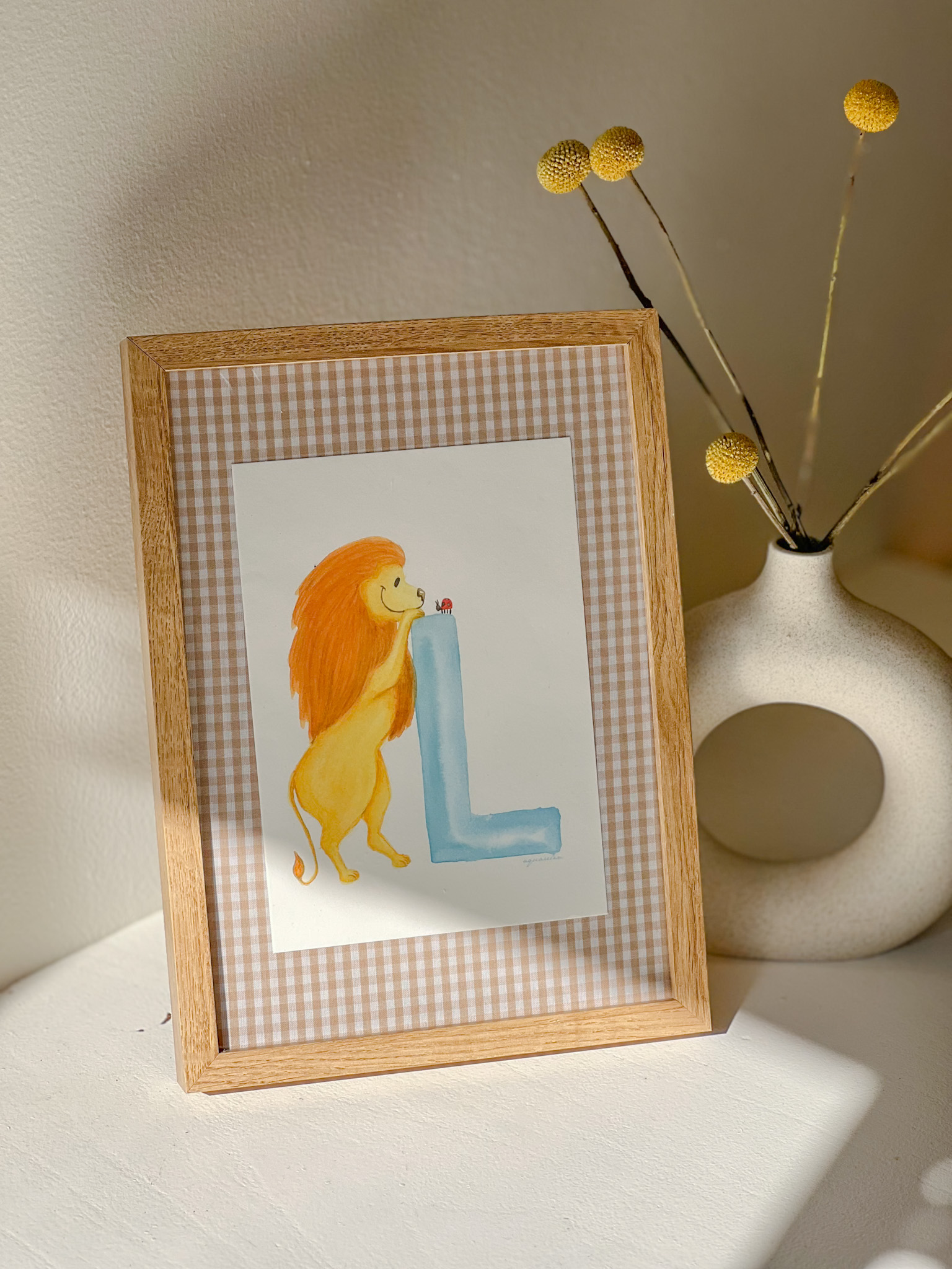 Framed illustration of the letter L with a corresponding animal, designed for nursery wall art.